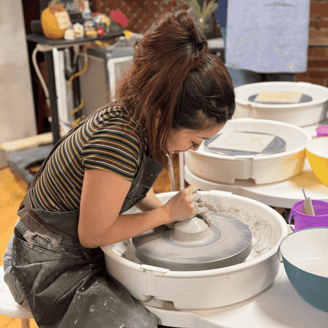 Volunteer working at the pottery wheel