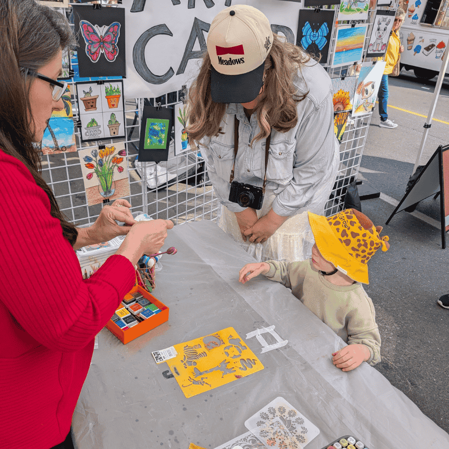 Volunteers and families creating art together at Happy Hands Studio